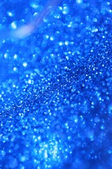 blue glitter  with bokeh background.Christmas festive winter background.Shiny texture with highlights. Blue shining bokeh surface. sparkling shiny  paper.Christmas seasonal wallpaper