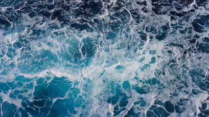 Fototapeta premium Texture of marine splashes. crashing ocean wave foam structure. Dark blue clear water. Ocean depth.