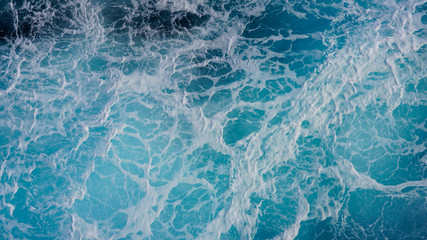 Texture of marine splashes. crashing ocean wave foam structure. Dark blue clear water. Ocean depth.