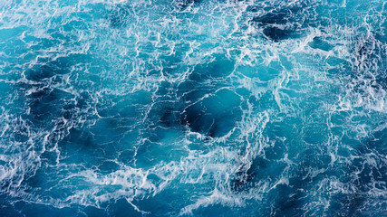Texture of marine splashes. crashing ocean wave foam structure. Dark blue clear water. Ocean depth.