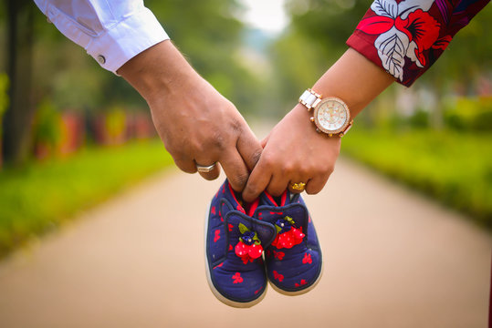 couple hands with baby shoe