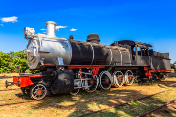 Naklejka premium Old retro preserved locomotive train standing on the rails in Livingstone, Zambia