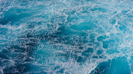 Texture of marine splashes. crashing ocean wave foam structure. Dark blue clear water. Ocean depth.