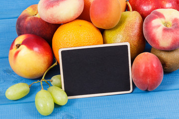Fresh fruits containing nutritious vitamins and black board for text, healthy lifestyles concept