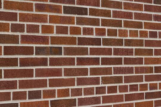 Vintage traditional red brown brick wall texture with common bond brickwork pattern (angle view)