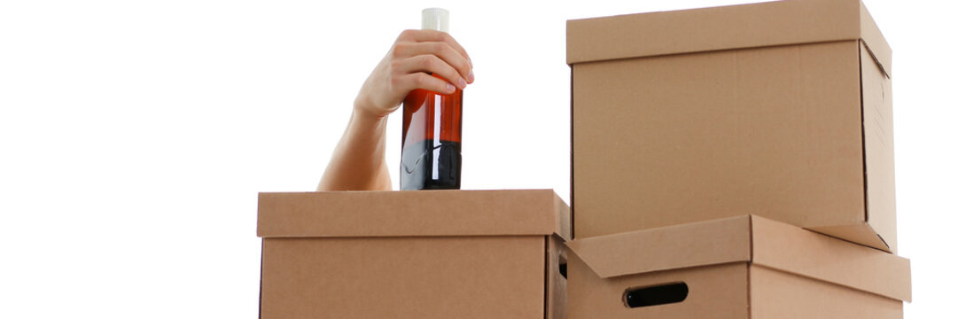 Hand specialist courier delivery service holding botle in hand background of boxes carried out delivery but could not due fact that he drank everything now in a drunken state can not work as a loader.