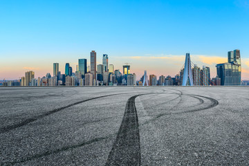 Empty race track ground and city financial district with buildings in Chongqing at sunrise,China.