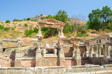 Fototapeta na wymiar Turkey, Aegean, Izmir. Ruins of ancient Greek city Ephesus (Efes). Columns of white marble, destroyed buildings. Famous open-air museum. Popular tourist location. Selective focus.