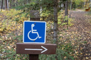 handicap sign for the forest hiking trail, trail direction in Kamloops near Isobel Lake. Accessible path for disabled, wheelchair.