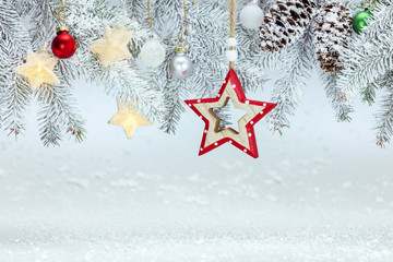 cold frosty white winter background. christmas tree branch under snow with holiday decorations
