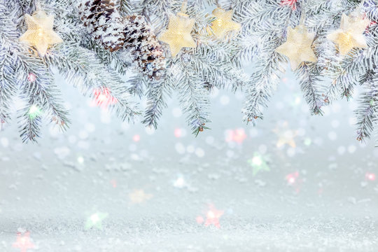 Christmas Tree Branch Under Snow Decorated With Glowing Star Lights Garland. Frosty Winter Background