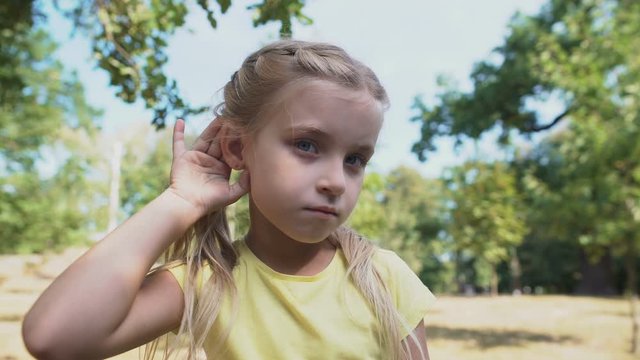 Girl touching ear, eavesdropping gossips, child hearing loss problem, deafness