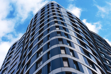 The appearance of new high-rise buildings made of glass and concrete on a blue sky background