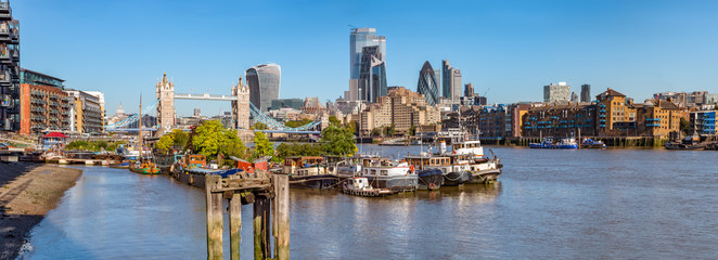 Panorama view of the Tower bridge over Thames river on a sunny day with wharf and boats. City...