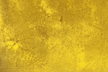 Dirty cracked concrete background painted in yellow paint