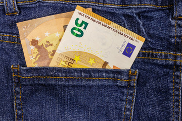 Fifty euro banknotes in the pocket of blue jeans