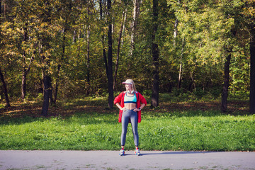 Fototapeta premium happy girl wearing headphones and sportswear training in the park