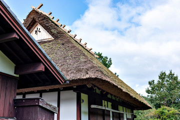 A traditional thatched roof Japanese house  preserved at a public park in Sanda, Hyogo, Japan.  Translation: A Japanese character on the roof means "water".