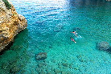people swimming scuba diving rocky scenic mali bok orlec natural beach on cres island croatia cristal clear water