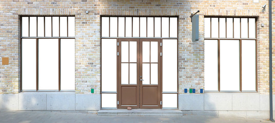 Modern mass production brown  plastic window frames and door is built in in a brick wall