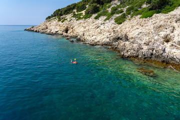 senior man snorkeling next to the rocky seashore on Croatia islands with turquoise water