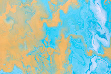 Free flowing paint. Yellow Waves and Curls on blue. Abstract marble background or texture