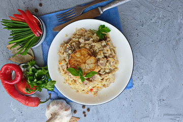 Pilaf-a traditional Oriental dish of rice, vegetables and meat served on an antique plate with fresh cilantro, sauces and spices, top view