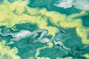 Free flowing yellow and green acrylic paint. Random Waves and Curls. Abstract marble background or...
