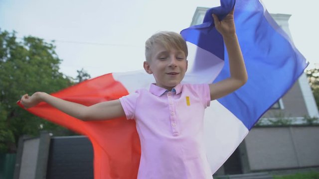 Young french football fan with flag cheering team outside, national championship