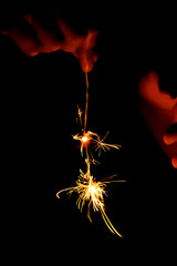 Sparklers burn and sparks scatter