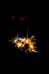 Sparklers burn and sparks scatter
