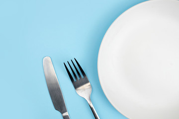 Top view of the plate and spoon on the blue background with the copy space.