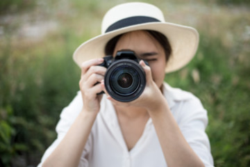 Asian woman holding camera take a photo.