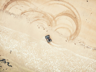 Extreme sport on quad bike beach of sea leaves traces. Aerial top view © Parilov