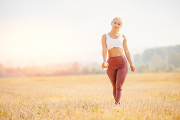 Young blond fitness woman runner athlete running park Sunrise