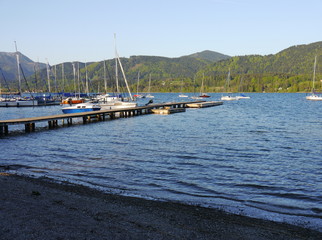Fototapeta premium lake in the mountains and sailboats in harbor on a beautiful sunny summer day with blue sky