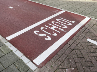 crosswalk for children near a school with the words school painted on the red colored asphalt