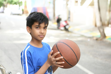 Fototapeta premium Portrait of Indian boy holding basketball