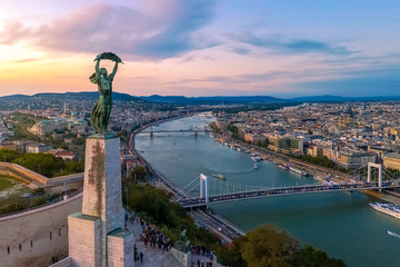 Fototapeta premium Pejzaże miejskie Budapesztu tworzą wzgórze Gellerta. Niesamowity zachód słońca w tle. Obejmował Dunaj, historyczne mosty, Dwontown Budapesztu,