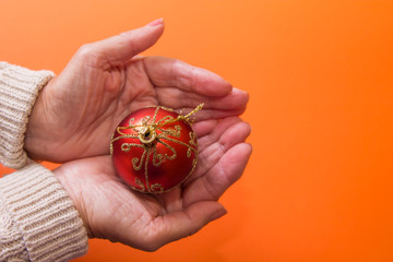 woman holding christmas ball in hands