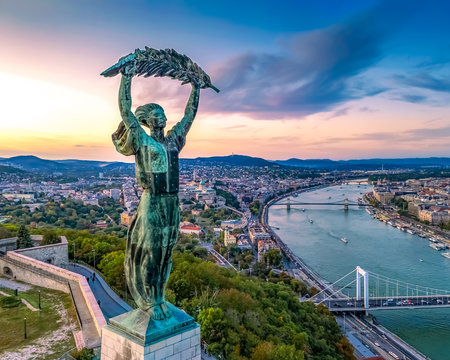 Budapest cityscapes form Gellert Hill with Citadella monument. Amazing sunset in the background. Included the Danube river, historical bridges, Budapest dwontown, 