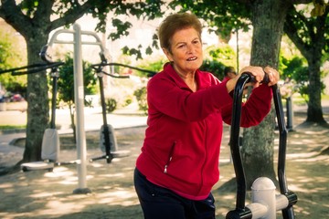 Obraz premium happy senior woman doing exercises and gymnastics outdoors