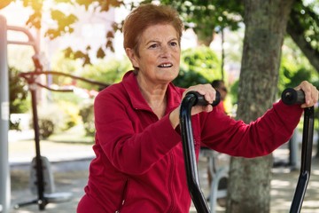 happy senior woman doing exercises and gymnastics outdoors