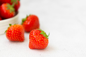 Fresh strawberry on white background in white bowl, fresh fruits for breakfast or healthy food snack, copy space