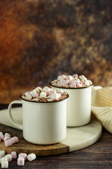 Two cups of hot chocolate, cocoa or warm drink with marshmallows on dark background