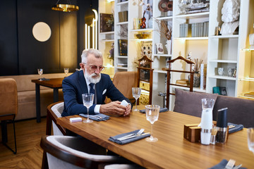 Elegant greybeard senior man buy electronic sigarette, testing e-cigarette. Stop smoke in social places