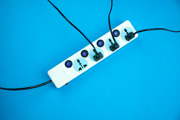 Electric power socket and plug on blue paper background