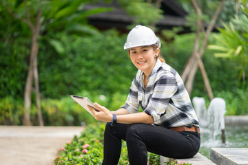 World environment day concept ,Thai Asian Female engineering working with a tablet laptop at sewage treatment plant, engineer controlling the quality of water , aerated activated sludge tank