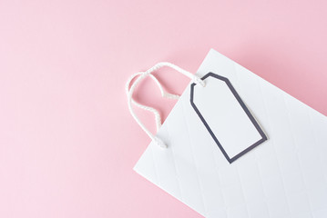 White shopping bag on pink background, top view
