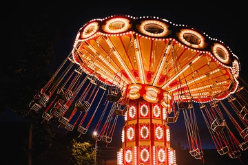 Fotobehang Amusementspark Verlichte draaikettingcarrousel in pretpark & 39 s nachts